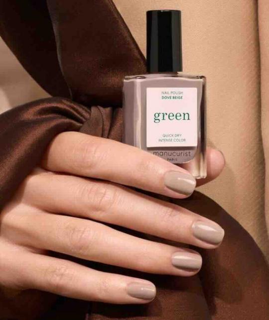 Main féminine tenant le vernis Dove Beige Manucurist GREEN™ - manucure naturelle L'Officina Paris