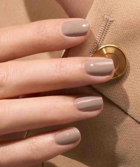 Main féminine avec manucure Dove Beige - vernis pastel aux sous-tons gris GREEN™ Manucurist L'Officina Paris