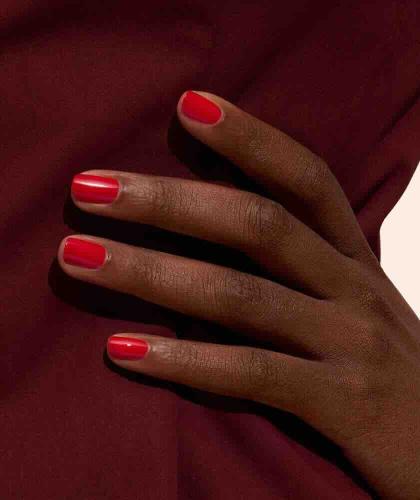 Poppy Red GREEN™ Manucurist, manucure rouge intense sur mains à la peau bronzée