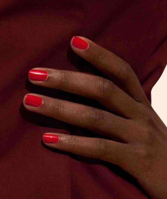 Poppy Red GREEN™ Manucurist, manucure rouge intense sur mains à la peau bronzée