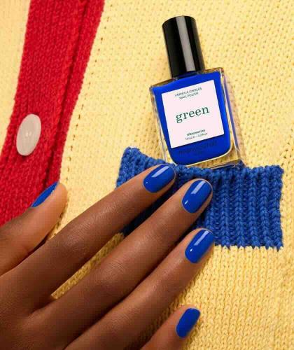 Vernis bleu électrique Ultramarine Manucurist avec flacon présenté sur une maille jaune colorée.