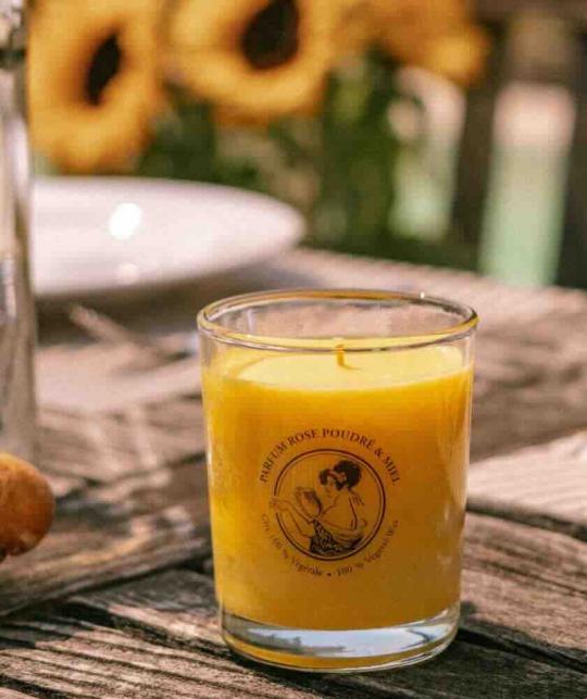 Rose & Honey scented candle by Féret Parfumeur on a wooden table outdoors