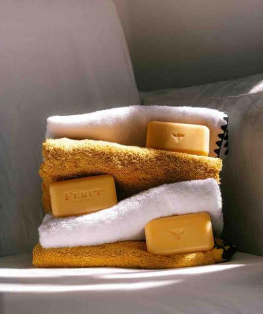 Féret Parfumeur Naturseife mit Honig in einer sanften und hellen Atmosphäre mit Badetuch