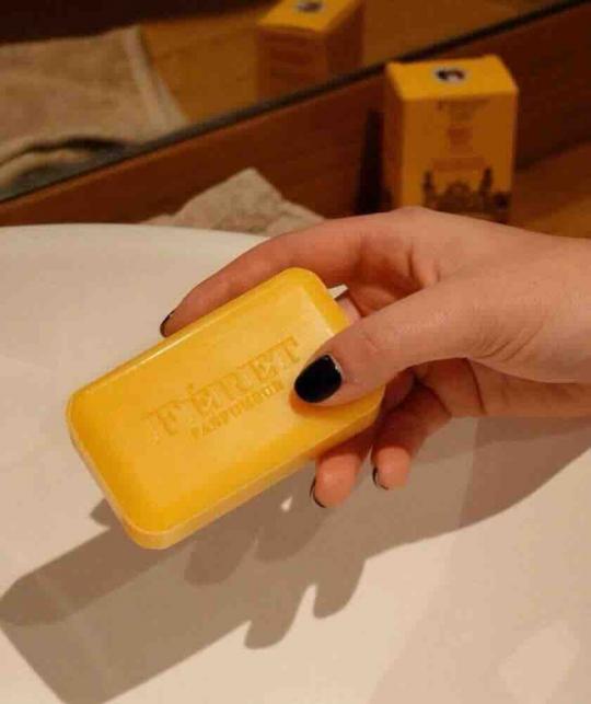 Savon Parfum Miel Féret Parfumeur dans les mains d’une femme au-dessus d’un lavabo, fabriqué en France