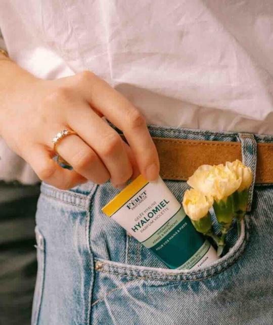 Féret Parfumeur Hyalomiel Violet Fragrance in a woman's jeans pocket with yellow flowers
