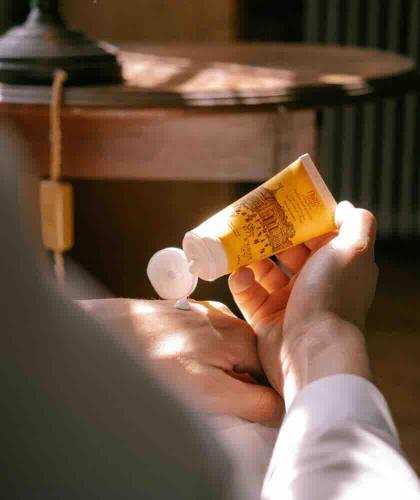Application de la crème mains et pieds au miel et karité Féret Parfumeur – soin quotidien dans une ambiance élégante